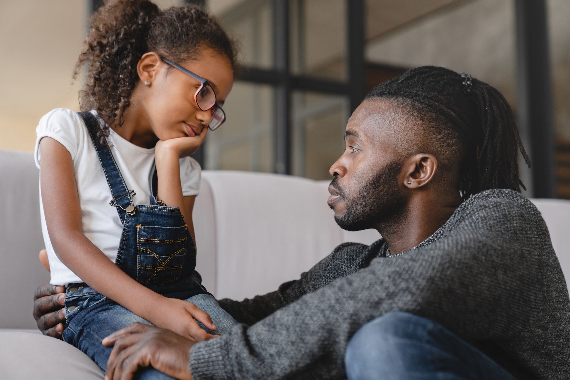 Dad listening to daughter`s problems with attention, supporting and calming her at home. Solving